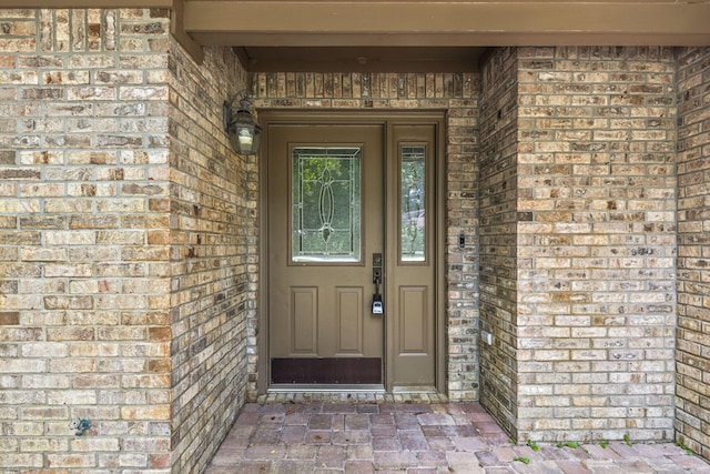 view of exterior entry with brick siding