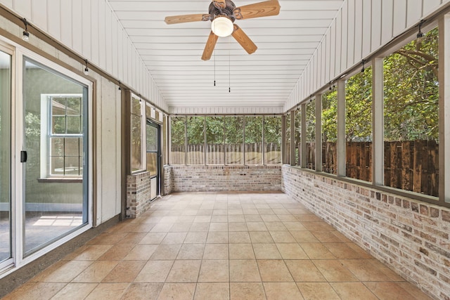 unfurnished sunroom featuring a ceiling fan