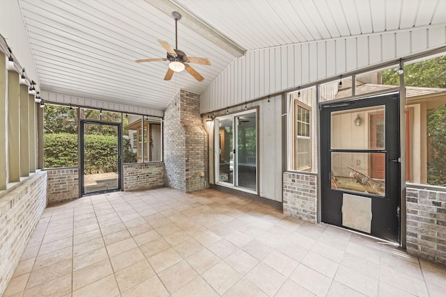 unfurnished sunroom with a healthy amount of sunlight, lofted ceiling, and ceiling fan