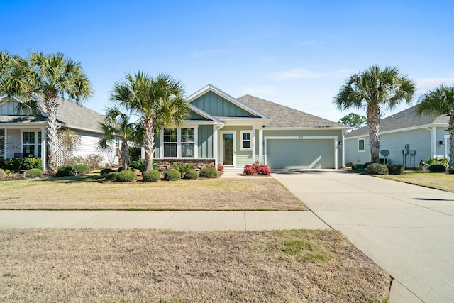 view of front of home featuring concrete driveway, an attached garage, board and batten siding, and a front yard