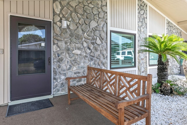 view of exterior entry with stone siding and board and batten siding