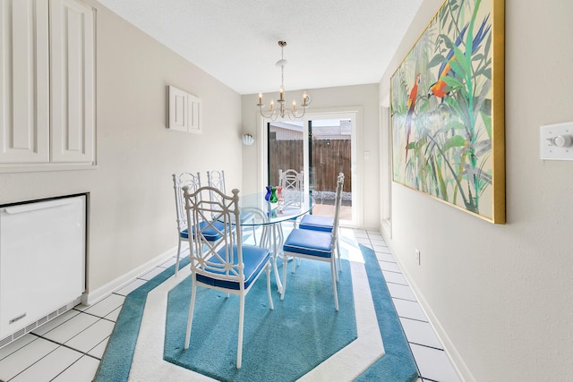 dining area with an inviting chandelier, light tile patterned floors, baseboards, and a textured ceiling