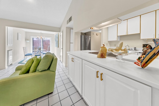 kitchen featuring white cabinetry, light countertops, light tile patterned floors, and freestanding refrigerator