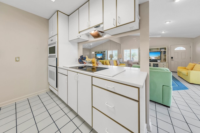 kitchen with light tile patterned floors, black electric stovetop, oven, and open floor plan