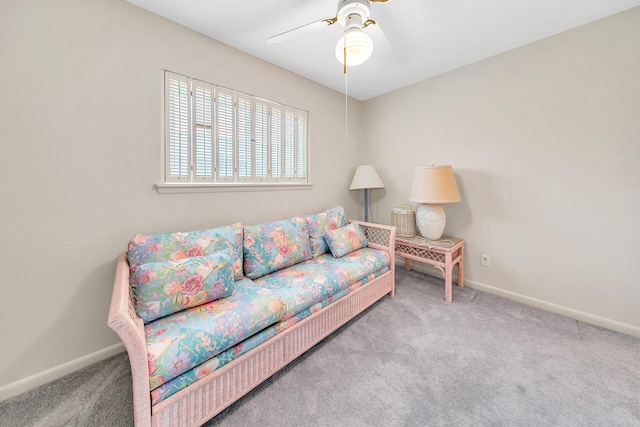 living area with baseboards, carpet, and a ceiling fan