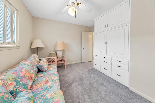 living room featuring baseboards, light carpet, and a ceiling fan