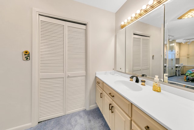 bathroom featuring a closet, vanity, and baseboards