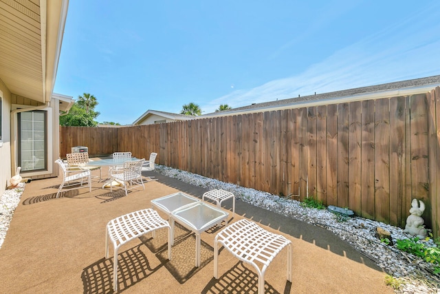 view of patio featuring outdoor dining space and fence