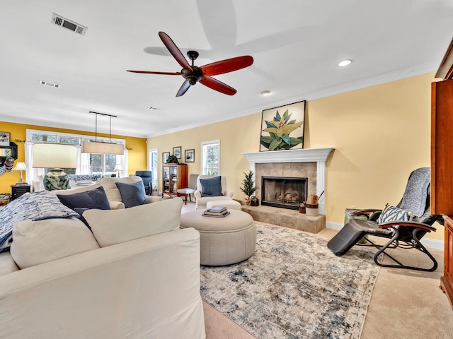 living room with a ceiling fan, crown molding, carpet, and visible vents