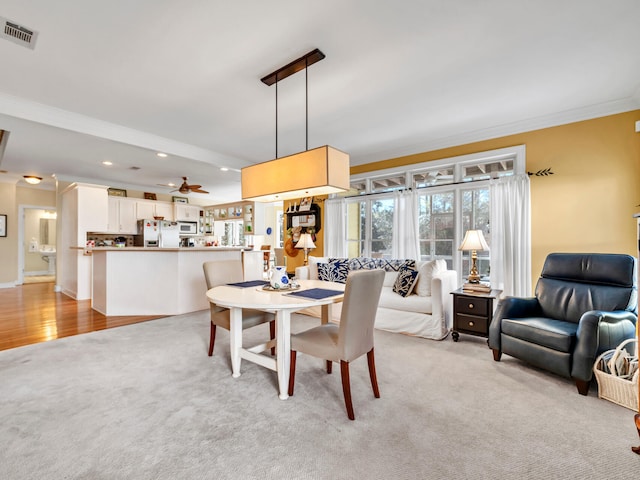 dining space featuring light carpet, recessed lighting, visible vents, and ornamental molding