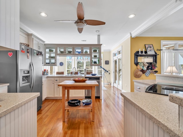 kitchen with light wood-type flooring, crown molding, a ceiling fan, and a sink