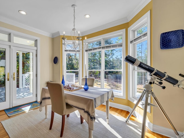 dining room featuring a healthy amount of sunlight, wood finished floors, and crown molding