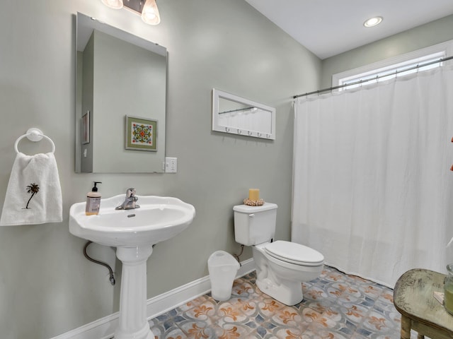 bathroom with tile patterned floors, curtained shower, baseboards, and toilet