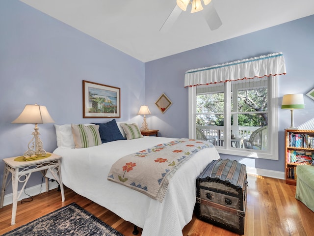 bedroom featuring baseboards, wood finished floors, and a ceiling fan