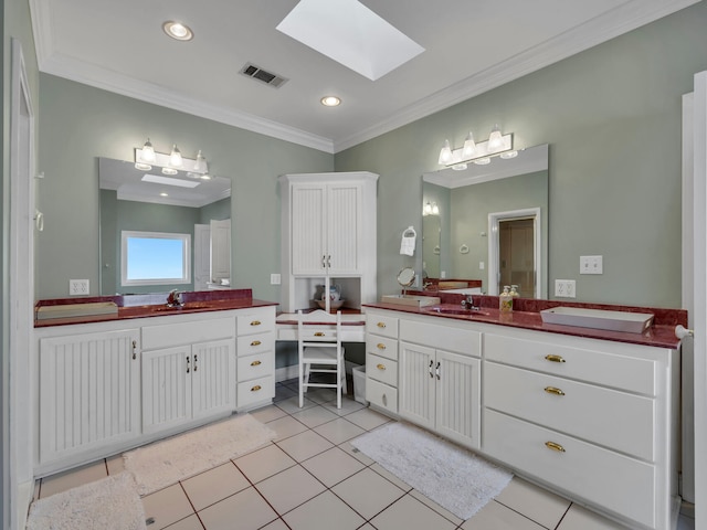 bathroom featuring visible vents, a skylight, two vanities, and a sink