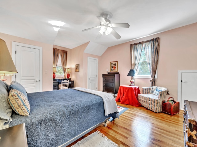 bedroom with lofted ceiling, a ceiling fan, and wood finished floors