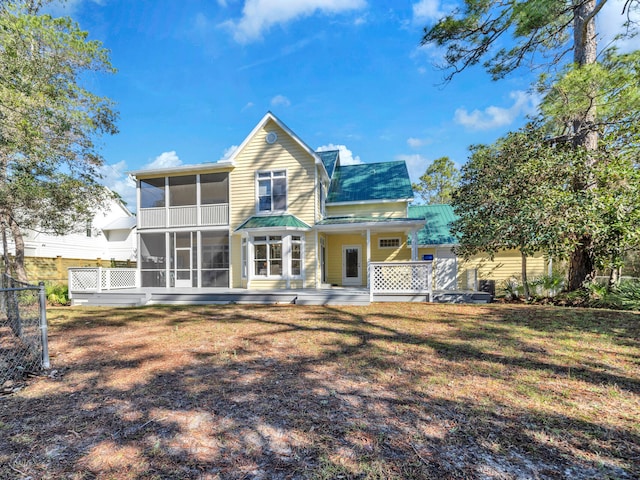 back of house featuring a yard and a sunroom