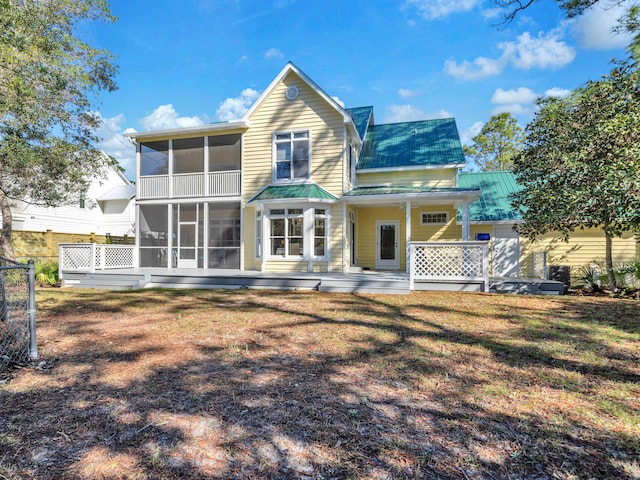 back of property featuring a lawn and a sunroom