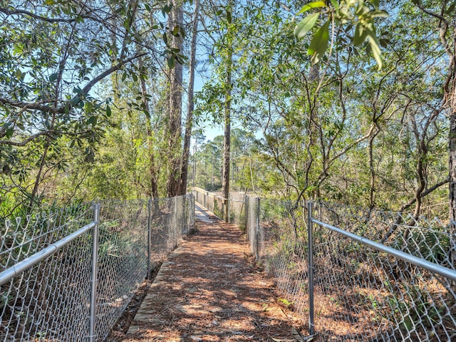 exterior space with fence and a forest view