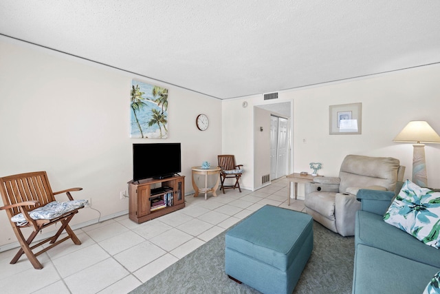 living area with light tile patterned floors, visible vents, and a textured ceiling