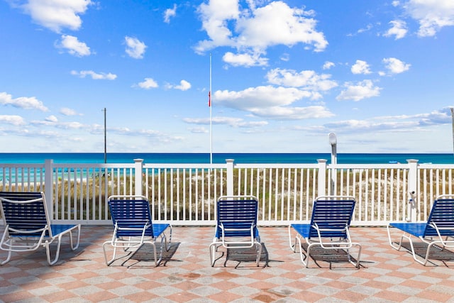 view of patio featuring a beach view and a water view