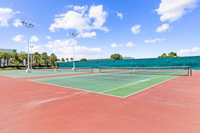 view of tennis court with community basketball court and fence