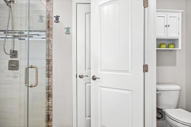 bathroom with toilet and a stall shower