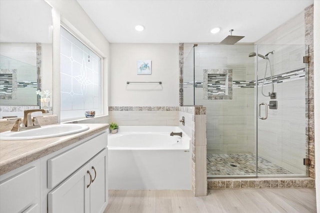 bathroom with vanity, a shower stall, and a garden tub