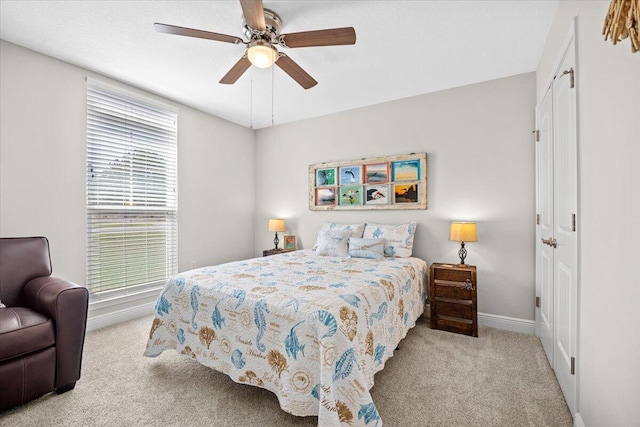 carpeted bedroom featuring baseboards and a ceiling fan