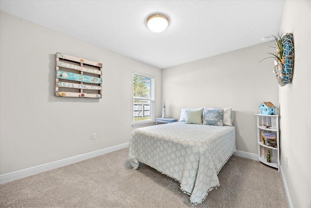 carpeted bedroom with a textured ceiling and baseboards