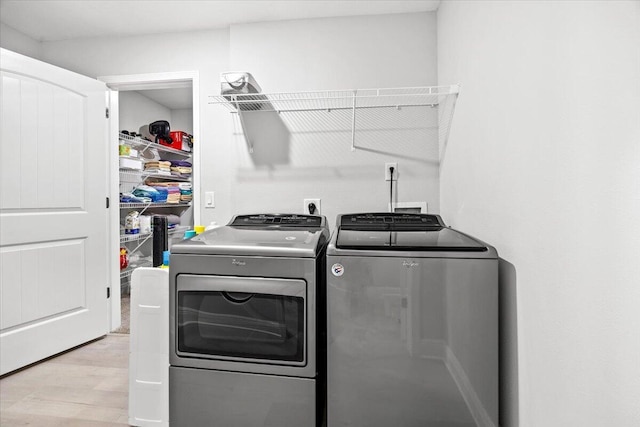 laundry area featuring laundry area, light wood-style flooring, and washer and clothes dryer