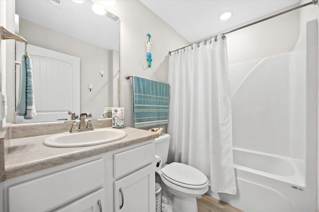 full bathroom with vanity, toilet, wood finished floors, and shower / tub combo