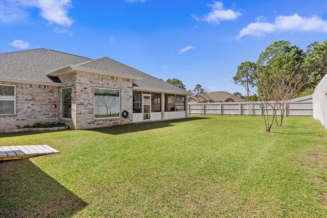 view of yard featuring a fenced backyard and a sunroom