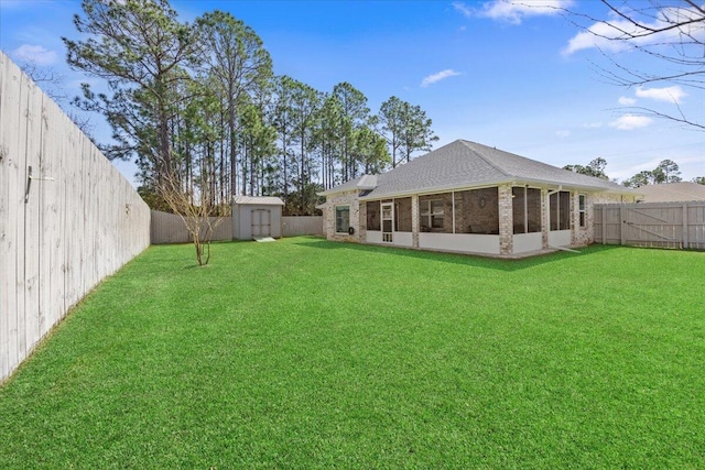 view of yard with a storage shed, an outdoor structure, a fenced backyard, and a sunroom