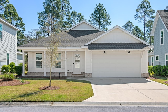 ranch-style house with roof with shingles, concrete driveway, a front lawn, a garage, and board and batten siding