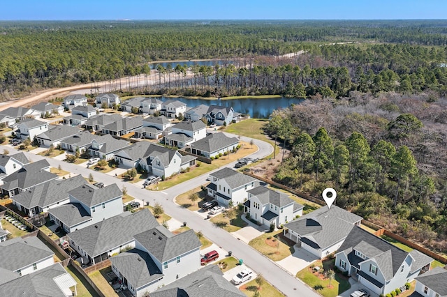 aerial view featuring a residential view, a water view, and a wooded view