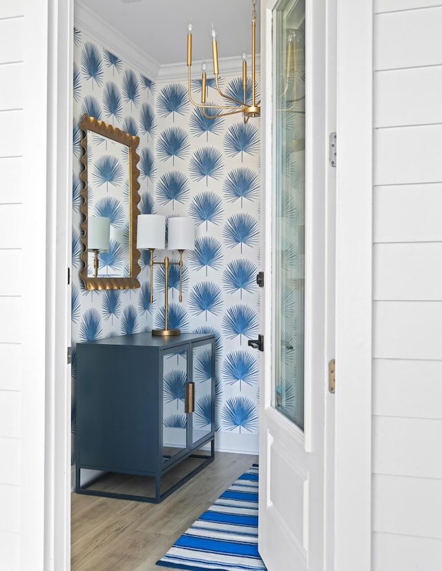 bathroom with wallpapered walls, crown molding, and wood finished floors