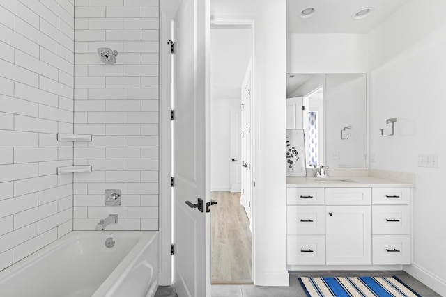 bathroom with baseboards, shower / bathtub combination, and vanity