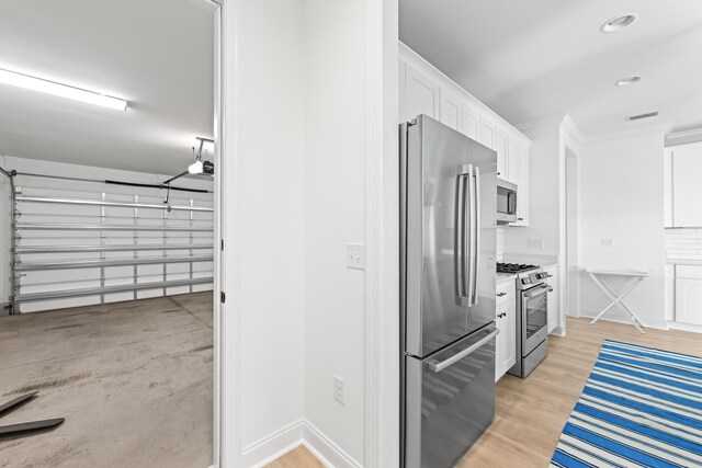 kitchen with stainless steel appliances, visible vents, light wood-style flooring, and white cabinetry