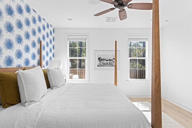 bedroom with light wood-type flooring, baseboards, visible vents, and ceiling fan