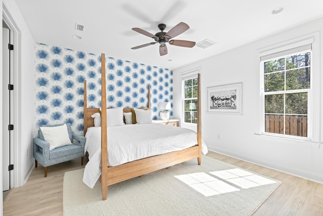 bedroom with visible vents, a ceiling fan, light wood-type flooring, and baseboards