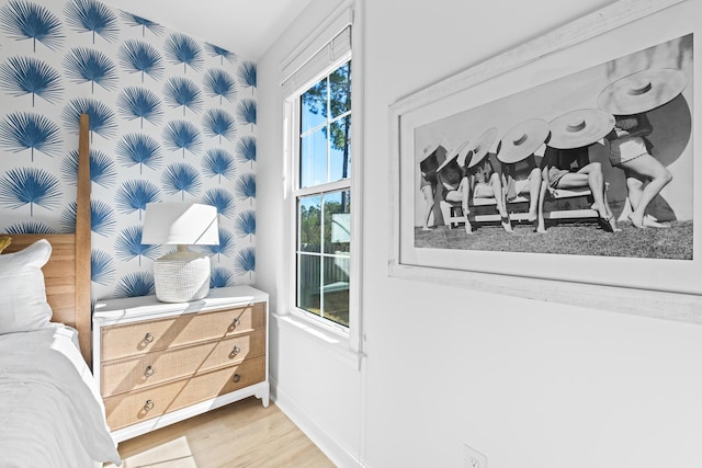 bedroom with wallpapered walls, baseboards, and light wood finished floors