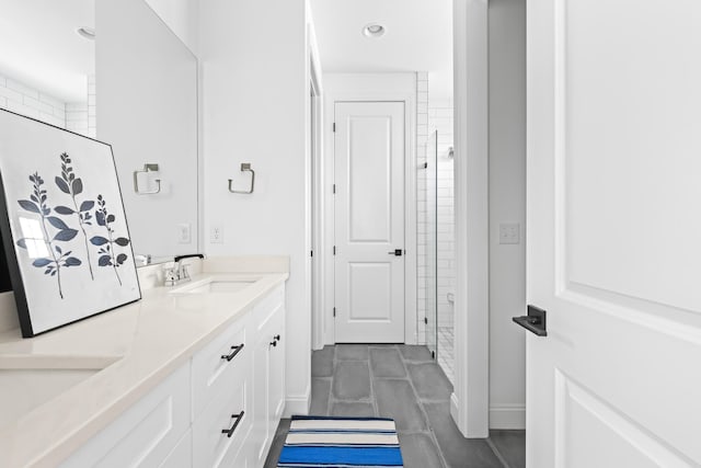 full bathroom featuring a sink, a stall shower, and double vanity