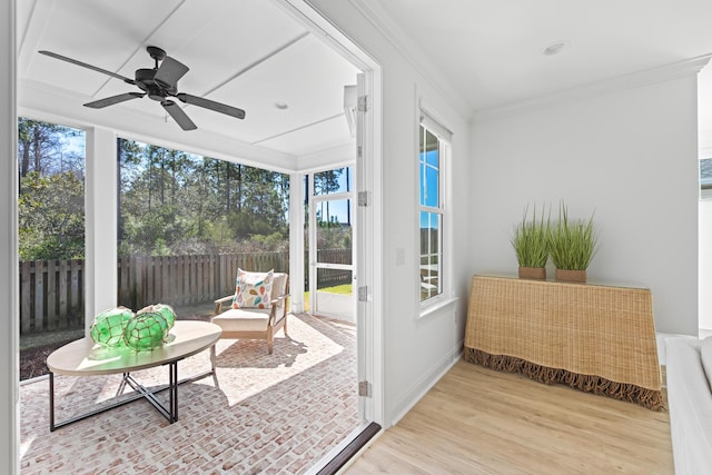 sunroom / solarium featuring a ceiling fan