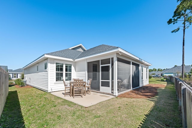 back of property with a patio, roof with shingles, a fenced backyard, a sunroom, and a lawn