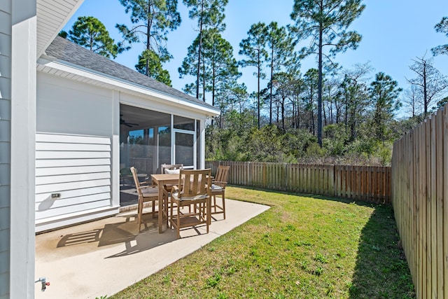 view of yard featuring a ceiling fan, a patio, a fenced backyard, and a sunroom