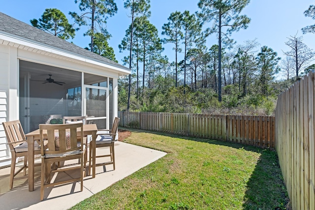 view of yard featuring a patio area, a fenced backyard, a ceiling fan, and a sunroom