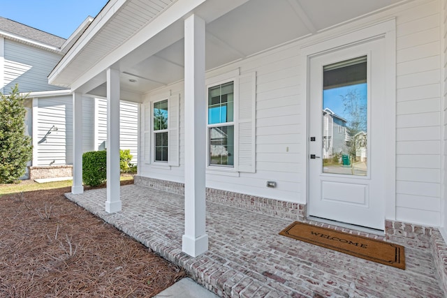 property entrance with brick siding and covered porch