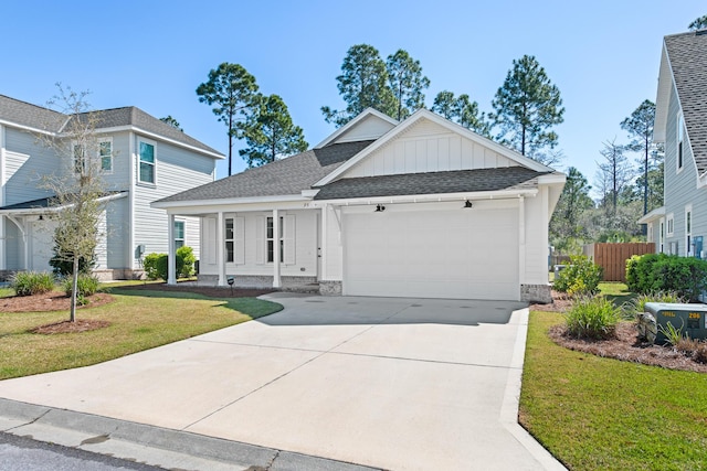 view of front of house with board and batten siding, fence, concrete driveway, a front yard, and a garage