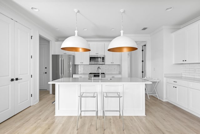 kitchen featuring a sink, light wood-type flooring, appliances with stainless steel finishes, and light countertops